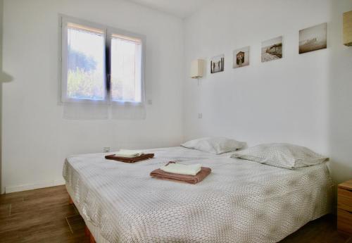 une chambre blanche avec un lit avec des serviettes dessus dans l'établissement Casa Maïtte, à Sotta