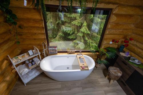 a bathroom with a large window and a bath tub at Casa Bucuriei - Plaiul Foii, Zărnești in Zărneşti