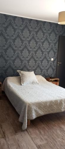 - une chambre avec un lit et un mur dans l'établissement Bienvenue a l hacienda, à Magalas