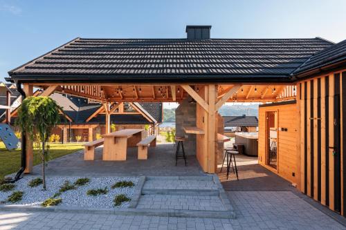 a wooden pavilion with a picnic table and a bench at Stylchyn Park - Czorsztyn Exclusive - by Upstairs in Kluszkowce