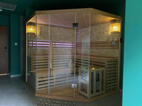 a wooden shower stall with glassdoors in a room at APARTAMENTY ZDROJOWA 9 in Duszniki Zdrój