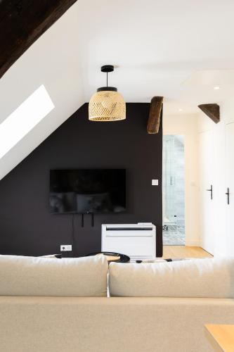 a living room with a couch and a black wall at Logement quartier historique in Tours