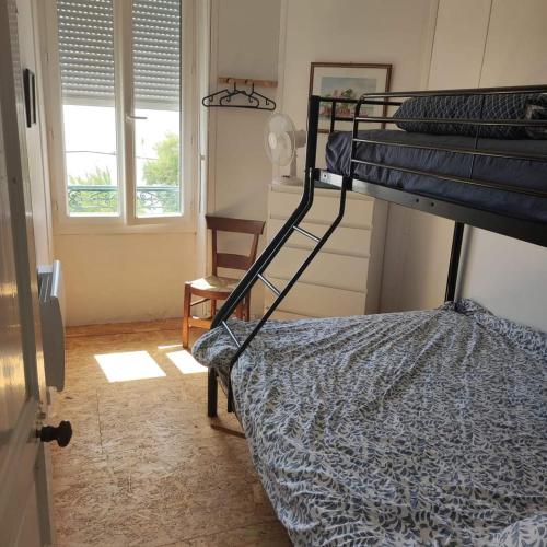a bedroom with a bunk bed and a window at Les galets in Fouras
