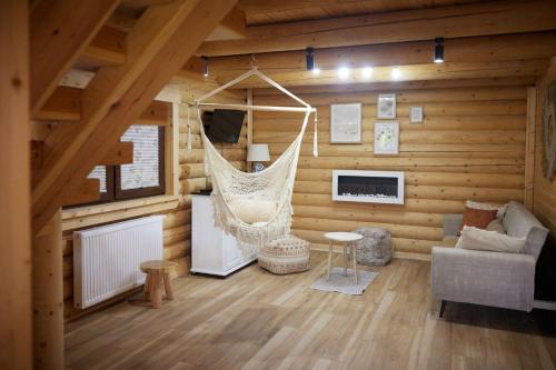 a room with a hammock in a log cabin at Domy z Bala - Domki ogrzewane - JACUZZI, SAUNA, lody, popcorn, ryba wedzona i ognisko w cenie! in Dziwnówek