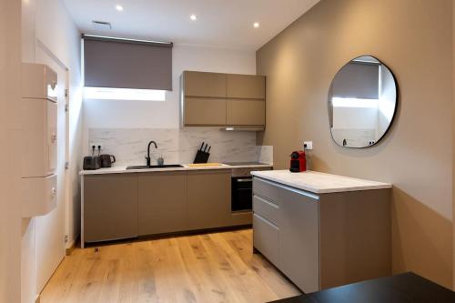 - une cuisine avec un évier et un miroir dans l'établissement Cœur de Metz Balnéo - La Suite 3, à Metz