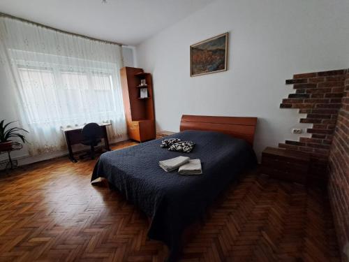 a bedroom with a bed with a blue comforter at APARTMENT POPS in Cluj-Napoca