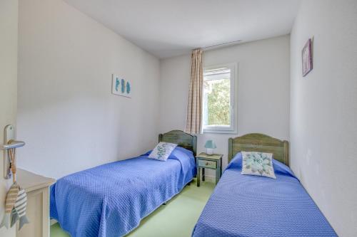 sypialnia z dwoma łóżkami i oknem w obiekcie Maison de ville Domaine des sables w mieście Soulac-sur-Mer