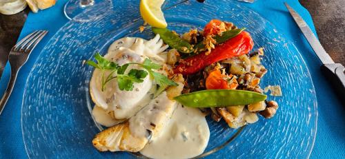 une assiette bleue de nourriture sur une table dans l'établissement Le confort proche de l'étang, à Marseillan