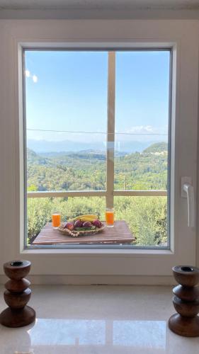 a room with a large window with a table with a view at Dinateli Houses - Live like a local in Corfu in Kastellánoi
