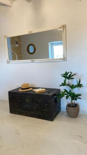 a black trunk sitting in a room with a mirror at Dinateli Houses - Live like a local in Corfu in Kastellánoi