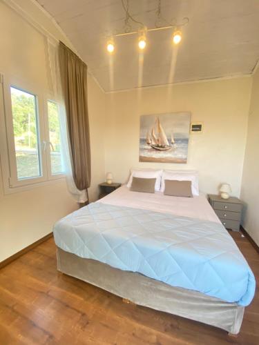 a bedroom with a large bed with a sailboat on it at Dinateli Houses - Live like a local in Corfu in Kastellánoi