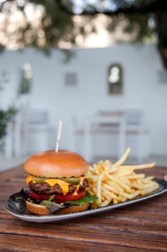 a plate with a hamburger and french fries on a table at Akti Hotel Kavala in Paleo Tsifliki