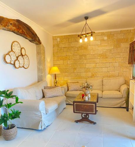 a living room with couches and a brick wall at Dinateli Houses - Live like a local in Corfu in Kastellánoi