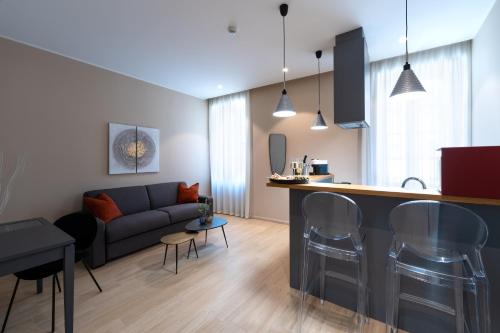 a living room and kitchen with a couch and a counter at Corte Novella Hotel & Residence in Brescia