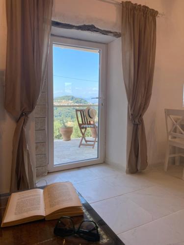 an open book sitting on a table next to a window at Dinateli Houses - Live like a local in Corfu in Kastellánoi