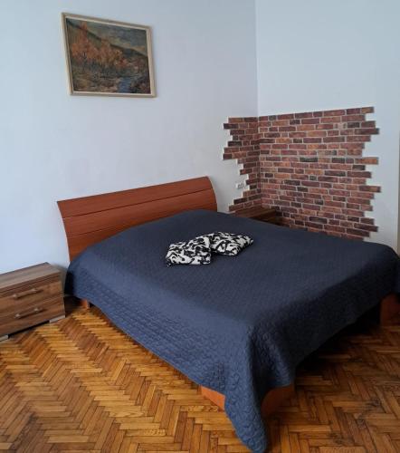 a bedroom with a bed and a brick wall at APARTMENT POPS in Cluj-Napoca
