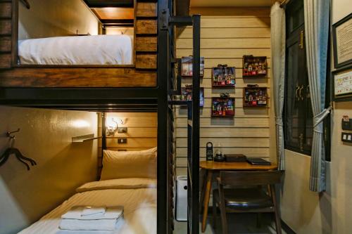 a room with a bunk bed and a desk at DE Phanakron Boutique Hotel in Bangkok