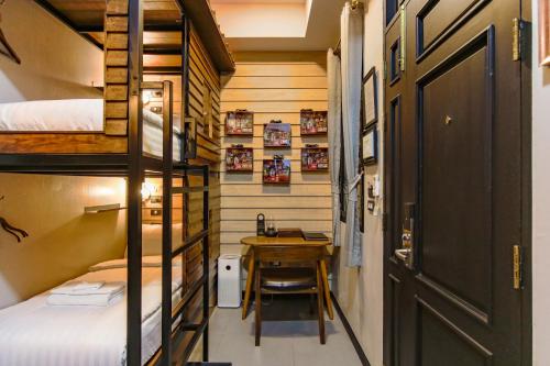 a small room with a desk and a bunk bed at DE Phanakron Boutique Hotel in Bangkok