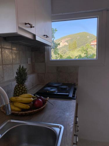 a kitchen counter with a bowl of fruit and a window at Dinateli Houses - Live like a local in Corfu in Kastellánoi