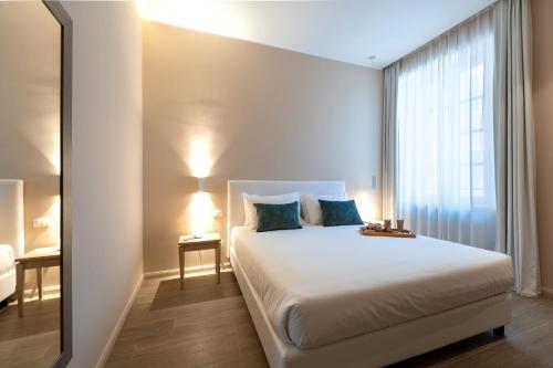 a bedroom with a large white bed with a window at Corte Novella Hotel & Residence in Brescia