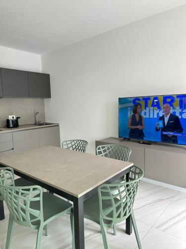 a kitchen with a table and chairs and a tv at Beach Palace with small swimming pool, private beach, parking in Lido di Jesolo