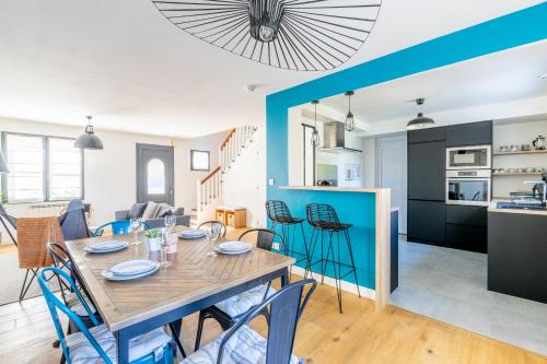 une salle à manger et un salon avec une table et des chaises dans l'établissement Le coin des Songes - Maison avec jardin, à Nantes