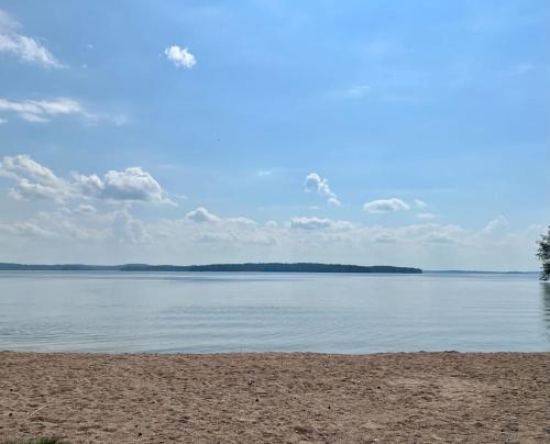 a view of a beach with the water and sky at Vääksy rivitalo 62 m2 in Asikkala