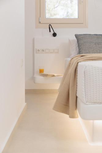 a white bedroom with a bed and a window at Country Villas in Stelida