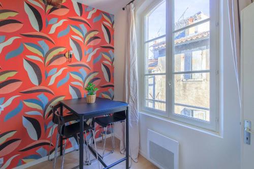 une petite table bleue dans une pièce avec un mur rouge dans l'établissement Coeur de ville, T2 lumineux et refait à neuf, à Arles