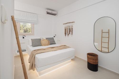 a white bedroom with a bed and a mirror at Country Villas in Stelida