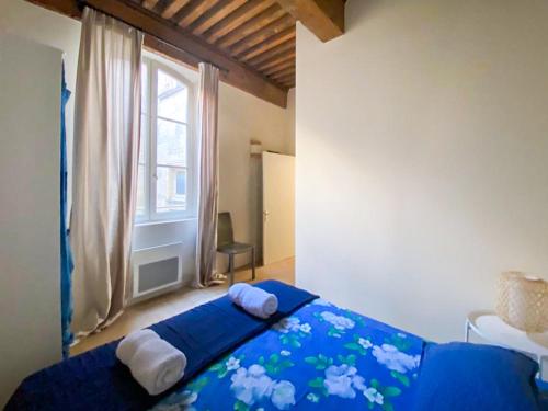 une chambre avec un lit bleu avec des serviettes dessus dans l'établissement Coeur de ville, T2 lumineux et refait à neuf, à Arles