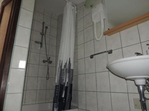a bathroom with a sink and a shower with knives at Apartments Brkanac in Umag