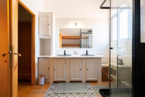 une salle de bain blanche avec un lavabo et un miroir dans l'établissement Villa Serrane - Appartement avec accès piscine, à Carqueiranne