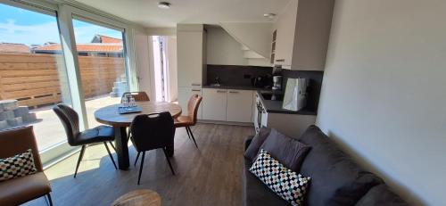 een woonkamer met een bank en een tafel bij 103B nieuwe vakantie woning met sauna vanaf juli 2024 in Westkapelle