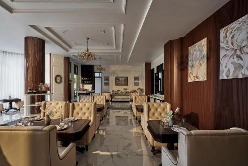 a restaurant with tables and chairs and a chandelier at NIA Hotel in Da Lat
