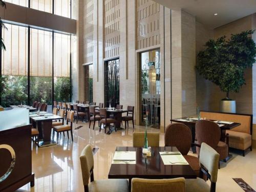 a restaurant with tables and chairs and windows at Putian Depo Hotel in Putian