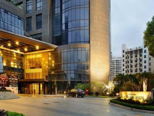 a car parked in front of a large building at Putian Depo Hotel in Putian