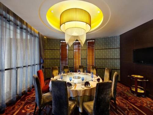 a dining room with a table and a chandelier at Putian Depo Hotel in Putian