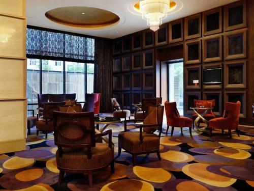 a lobby with chairs and tables on a rug at Putian Depo Hotel in Putian