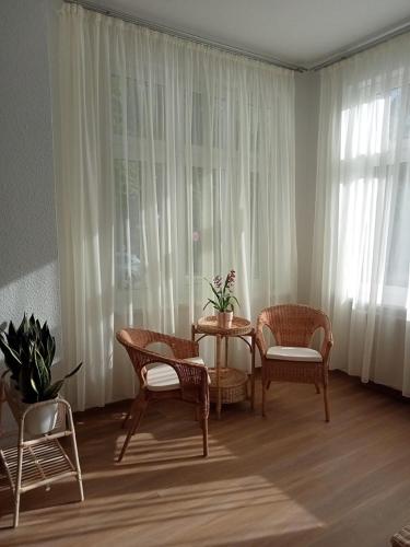 a living room with a table and chairs and a window at Haus Troja in Warnemünde