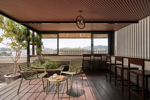 a patio with chairs and tables and windows at NIA Hotel in Da Lat