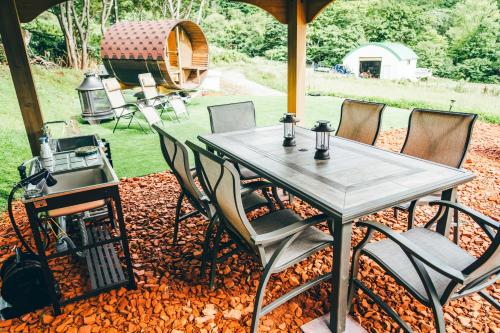 a table and chairs on a patio with a grill at 小別沢プライベートグランピングQuope in Sapporo