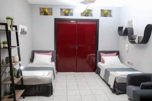 two beds in a room with a red door at CASTLE VIEW luxury apartment with Free Private Parking in Kavala