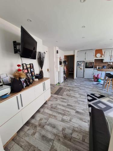 un salon avec une télévision au-dessus d'un comptoir dans l'établissement Appartement plein coeur de centre ville, à Beauvais