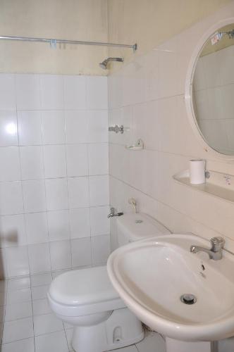 a white bathroom with a toilet and a sink at Mount Crest Inn Deniyaya in Deniyaya