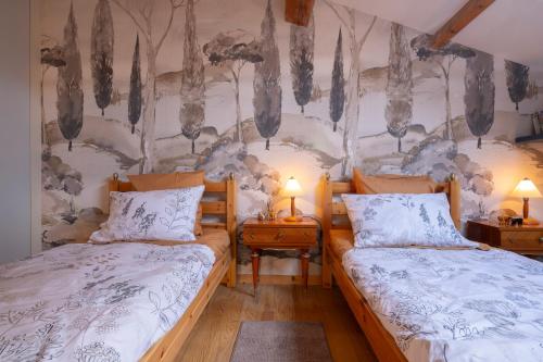 - une chambre avec 2 lits et un mur arboré dans l'établissement Villa Serrane - Appartement avec accès piscine, à Carqueiranne