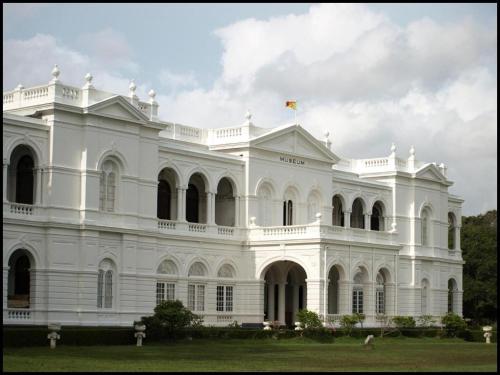 a large white building with a flag on top at OYO 299 Randula Grand Venus Hotel in Katuwalamulla