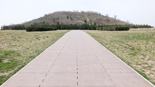 a walkway in a field with a mountain in the background at Kyriad Marvelous Hotel·Xi'an North High-speed Railway Station in Xi'an