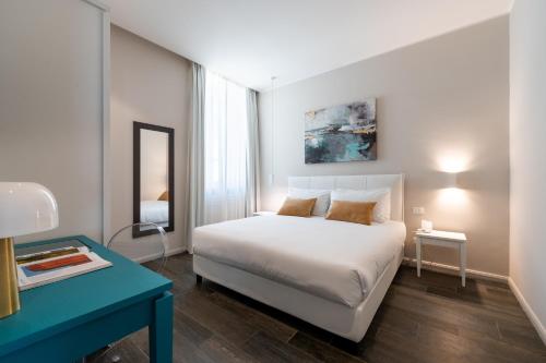 a bedroom with a white bed and a blue desk at Corte Novella Hotel & Residence in Brescia