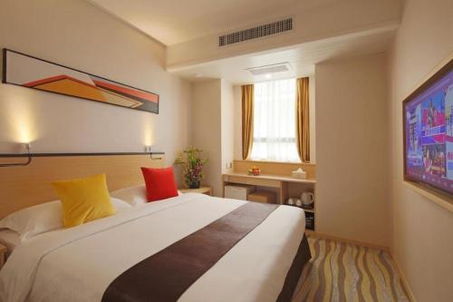 a bedroom with a large white bed with colorful pillows at Cozy Hotel Xiamen in Xiamen
